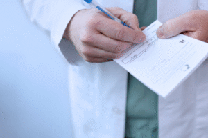 Lekarz w białym kitlu podpisujący dokument medyczny – wystawianie recepty lub zwolnienia lekarskiego