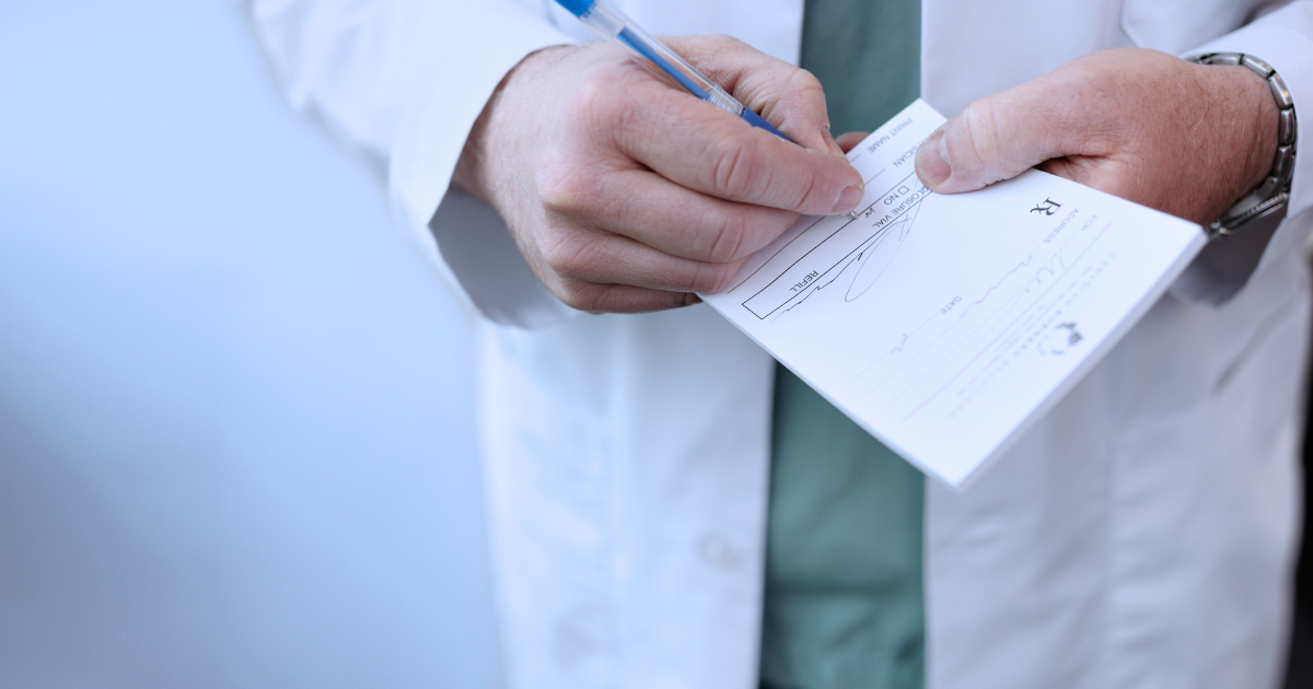 Lekarz w białym kitlu podpisujący dokument medyczny – wystawianie recepty lub zwolnienia lekarskiego