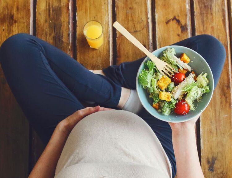 Kobieta w ciąży trzymająca miskę sałatki – zdrowa dieta i BMI w ciąży