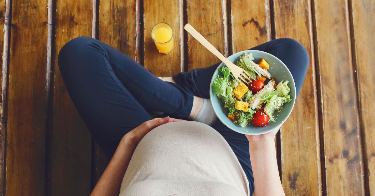 Kobieta w ciąży trzymająca miskę sałatki – zdrowa dieta i BMI w ciąży
